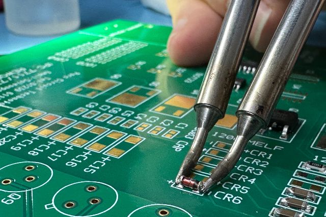 a close up of a small component being soldered to an electronics circuit board