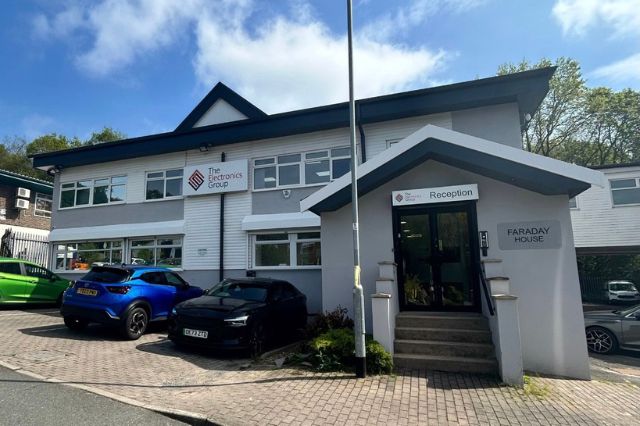 the outside of the electronics group training centre showing the front entrance and some cars parked out front