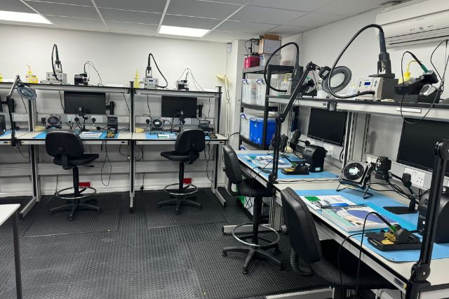 an electronics workshop at The Electronics Group training centre with work benches covered in soldering equipment and monitors