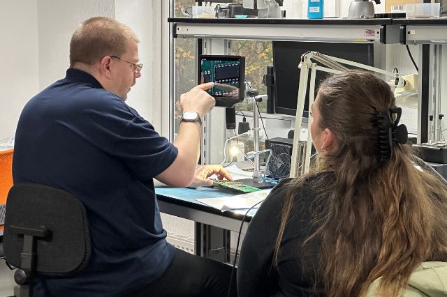 a certified IPC trainer showing a delegate something through a microscope on a PCB