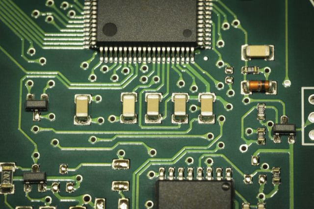a close up image of a PCB with soldered on components
