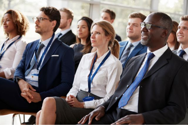 an engaged audience at a summit, all listening to a talk